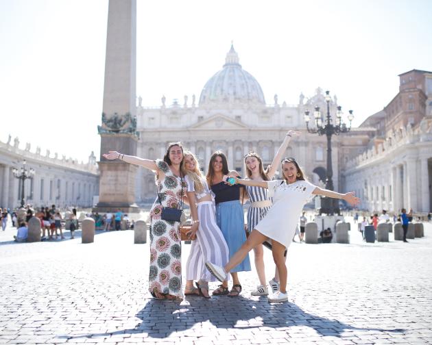 a group of students pose for a photo in St. Peter's Square in Rome