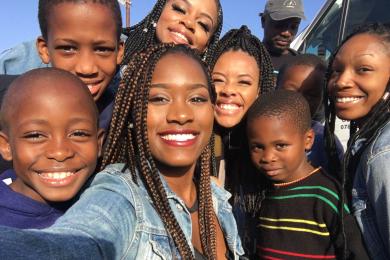 group selfie of cape town students smiling with kids in the sun