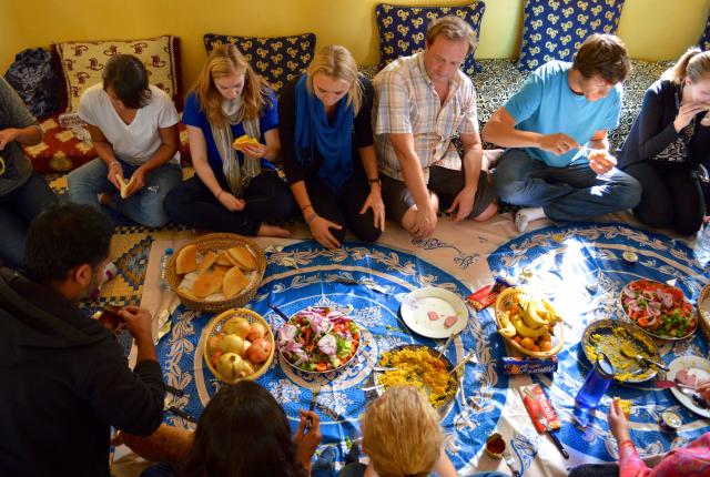 students sitting down on the floor having a traditional dinner in Rabat