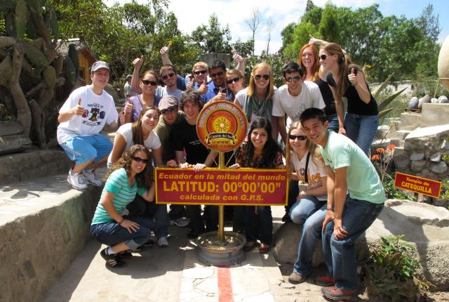 a group of students pose for a photo at the 0 latitude line at Mitad del Mundo (middle of the world)