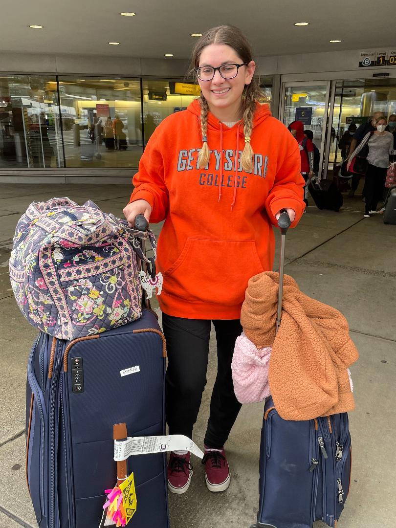 Girl standing with suitcases 