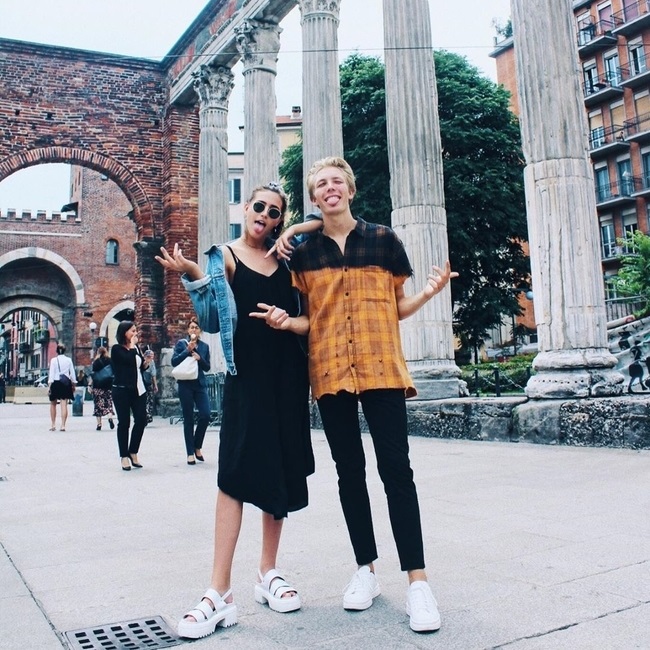 two students standing in front of ancient ruins