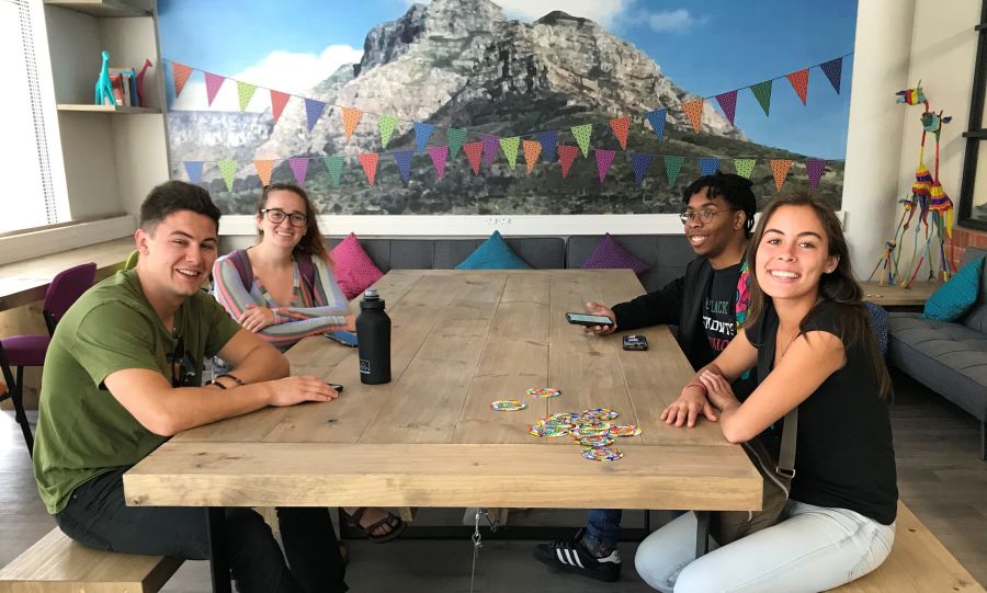 Students at the student lounge sitting at the table smiling