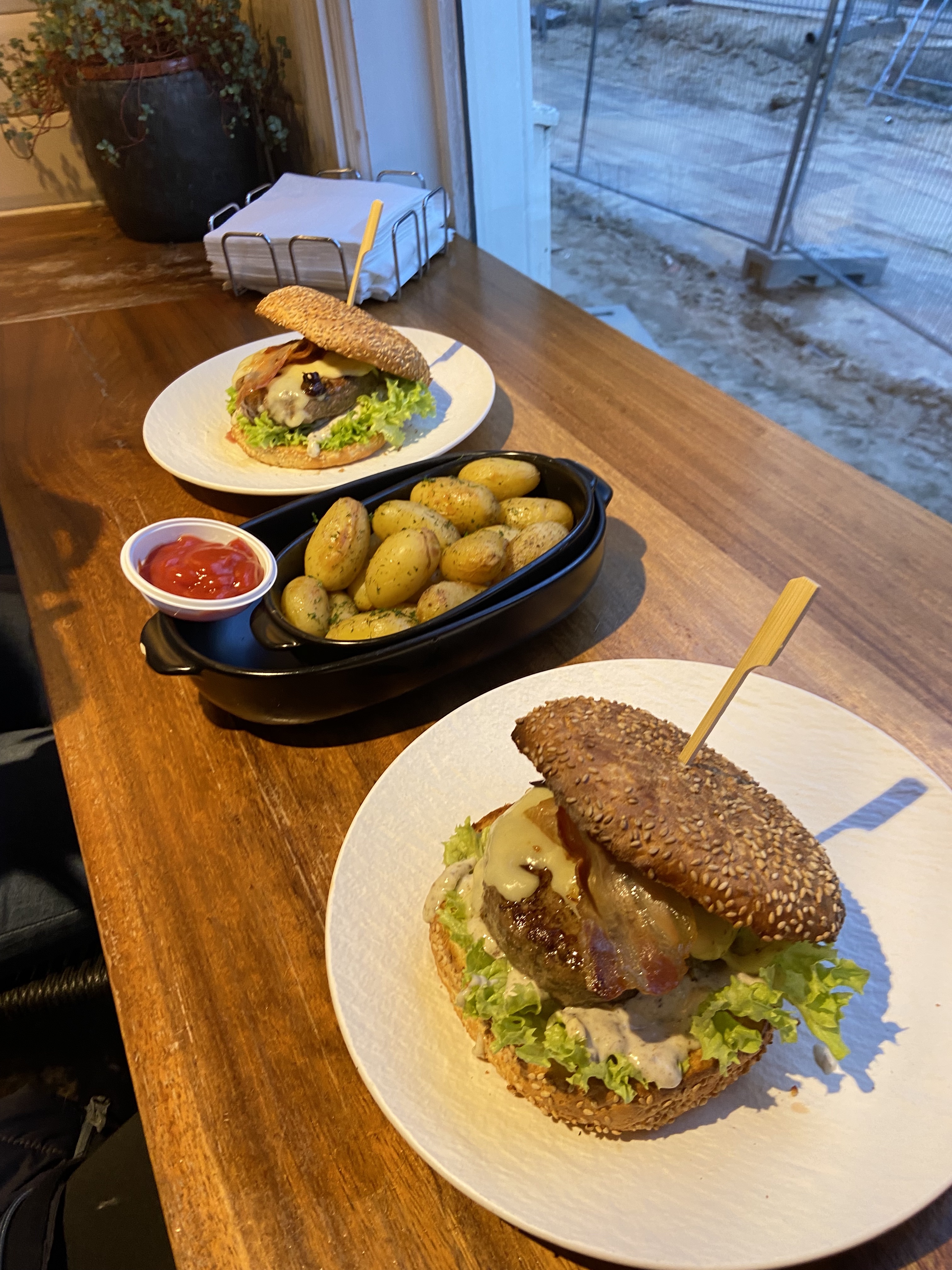 two burgers with cheese, truffles, and a selection of other toppings with roasted potatoes 