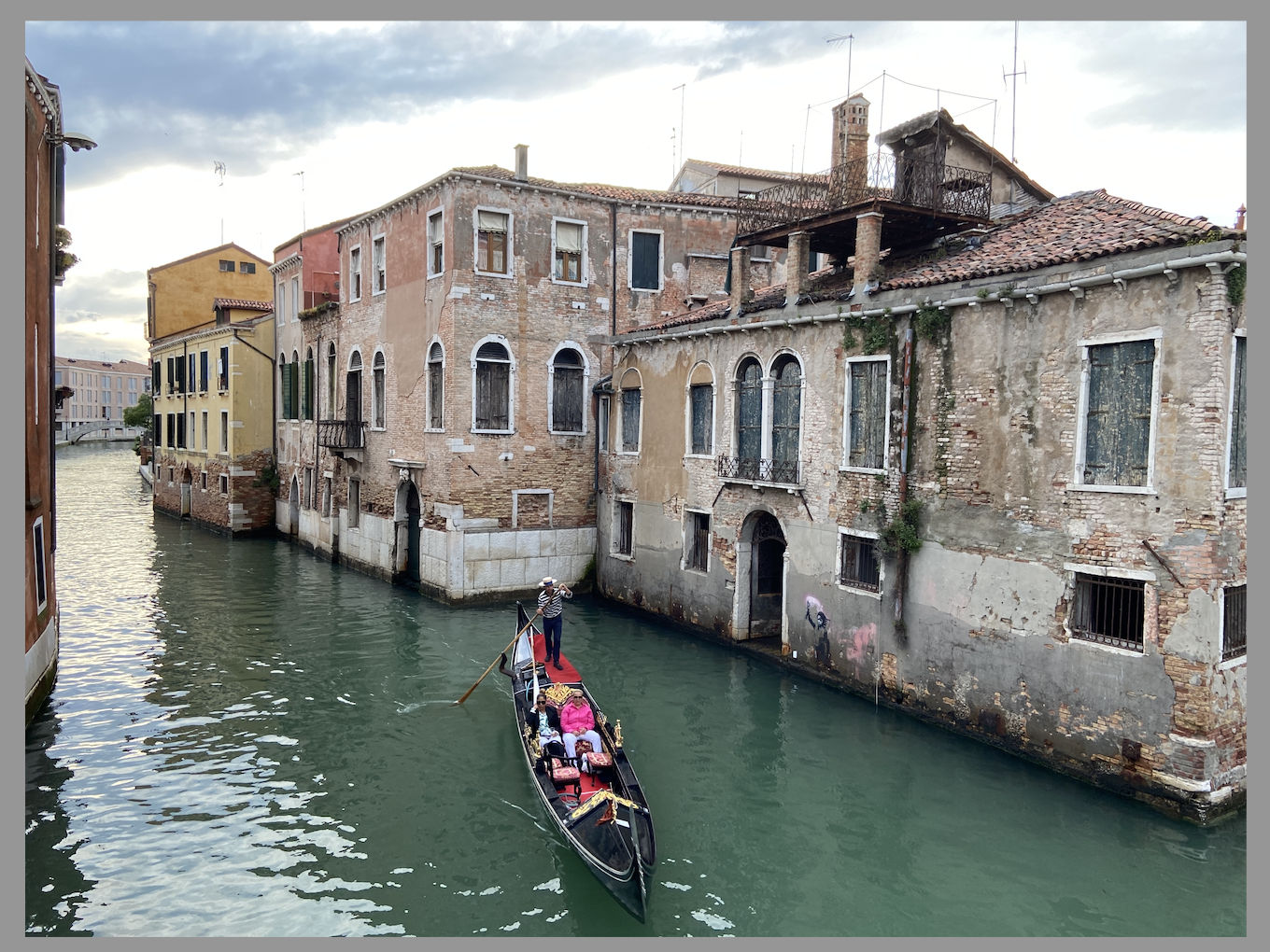 a picture of a canal with an unknown Banksy on the right 