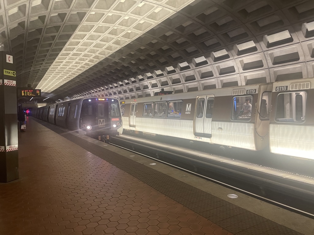 A photo of a D.C. Metro Train arriving, with another one in the backround.