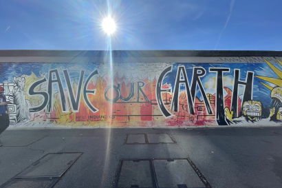 On the Berlin Wall is spray painted "Save Our Earth."