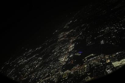 A picture taken through the plane window at night, hovering above the light-speckled outline of Florida in the direction of Germany.