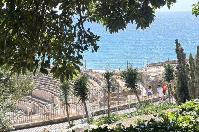 Ancient Amphitheater at a distance surrounded by trees and and water. 