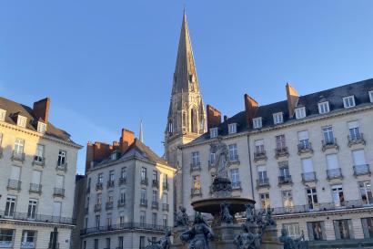 Square with fountain, tall gothic steeple in the background