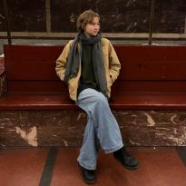 A girl with short hair sits at an U-Bahn station