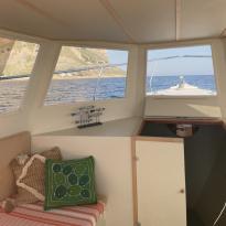 View of a bench inside a boat and out the window at the water