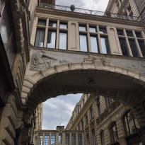 Two dramatic old stone arch bridges between buildings 