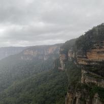 Another wide view of the Blue Mountains but with rocks peaking through the right-hand corner. 