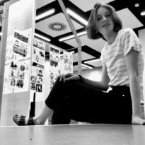 young woman in black and white against backdrop of lit house gallery 