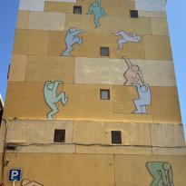 Wall with people spray painted to depict them climbing the levels of the building. 