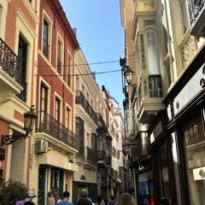 Narrow road surrounded by two rows of buildings on each side 