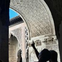 Two people pointing at an arch in a building 