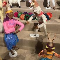 Photo of figures from primary nativity scene, colorful clothing with deer masks on head