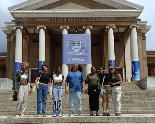 Students stand and smile in front of the University of Cape Town
