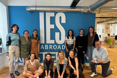 group of staff sitting and standing in front of blue wall that reads "IES Abroad Amsterdam"