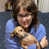 a headshot of Anna holding her dog