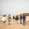Students in Rabat walk along a sandy beach to see the Hercules Caves.