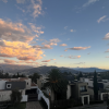 A picture of the sunsetting behind the Ecuadorian mountains with houses in the foreground. 