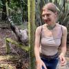 Girl standing by fence with an emu