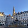 Square with fountain, tall gothic steeple in the background