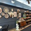 A picture of the wall at Lasa Filipino Cafe. Decorative weavings hang from the wall with shelves of plates and Filipino snacks along the wall.