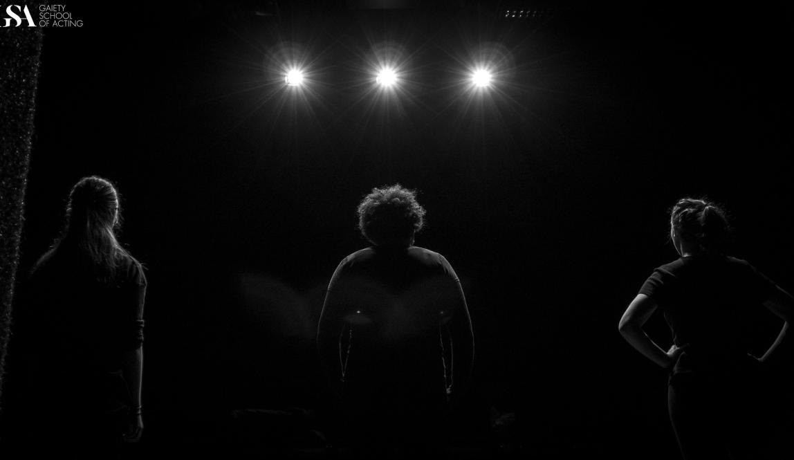 Dublin student standing on stage facing the spotlights