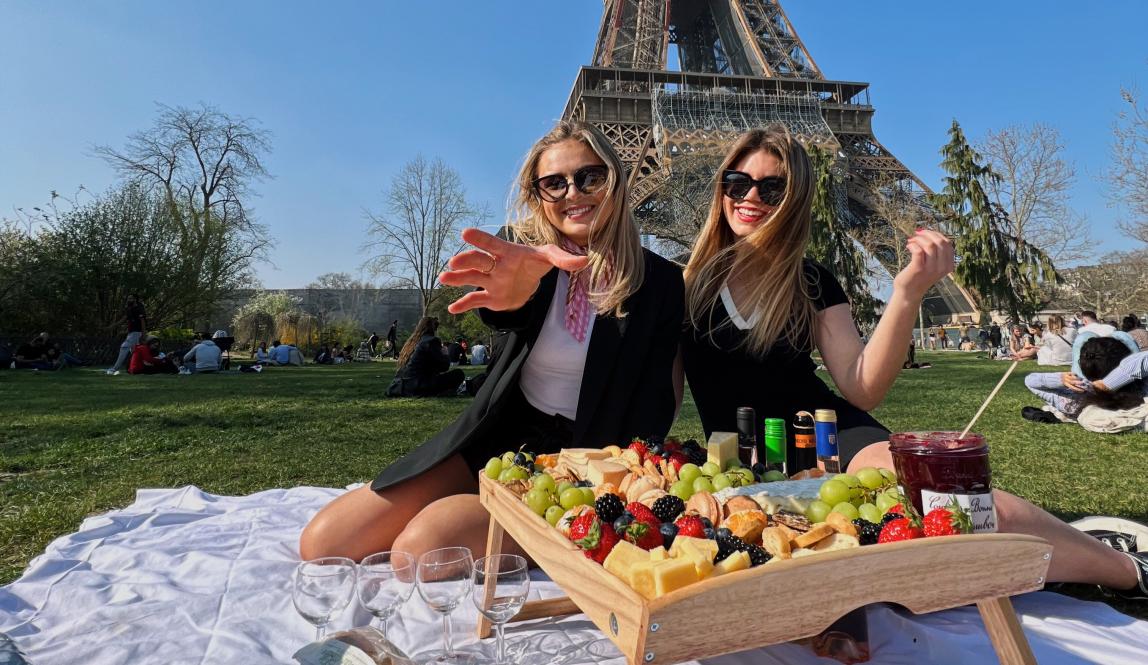 Two students having a picnic at the Eiffel Tower in Paris, France