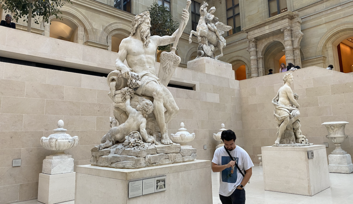 Student with statues at the Louvre in Paris, France