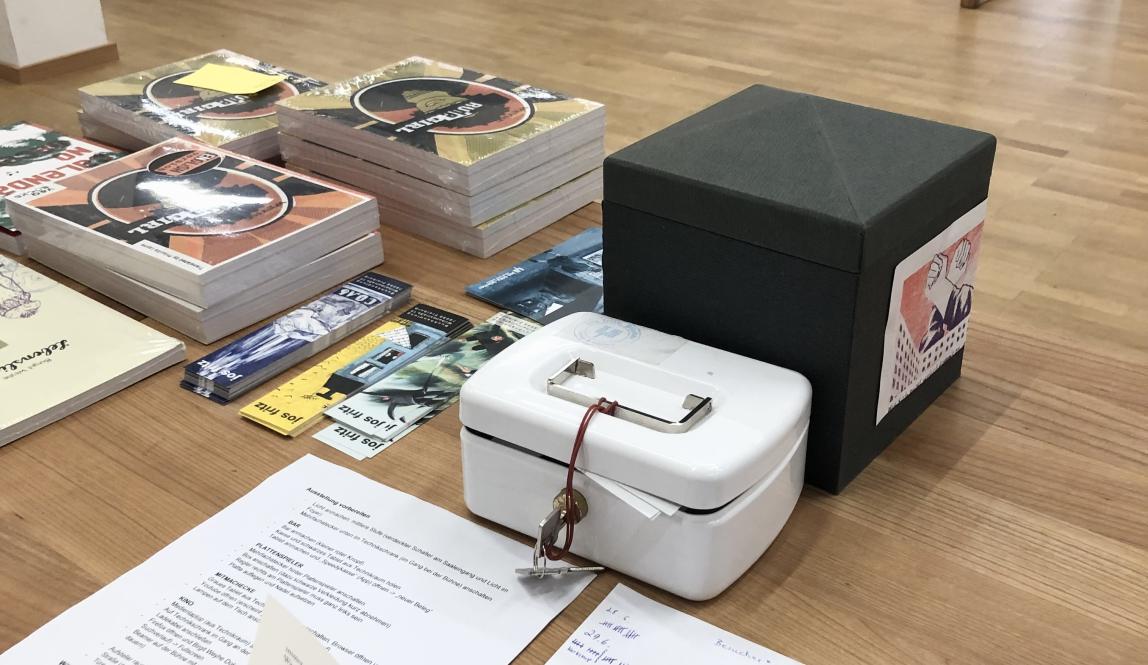 Book(s) open on check-in desk/bar; overseeing the exhibit 