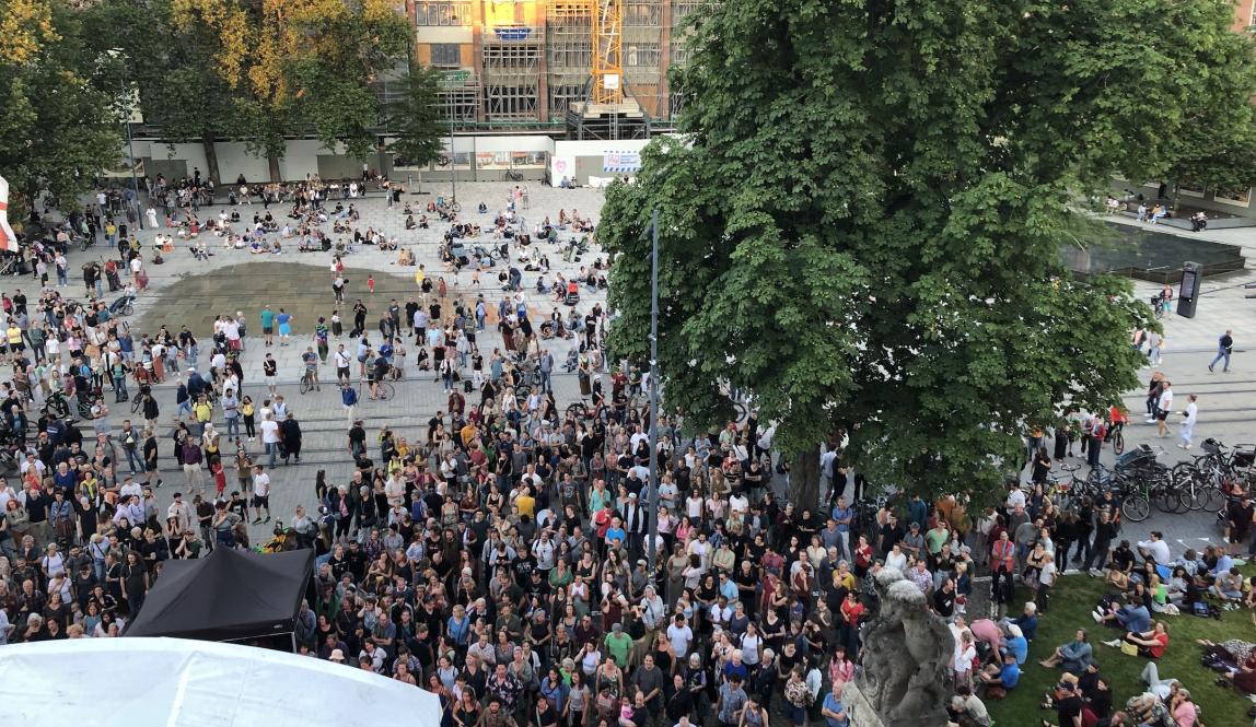 Crowd gathered in front of theater, photo taken from inside theater upstairs 