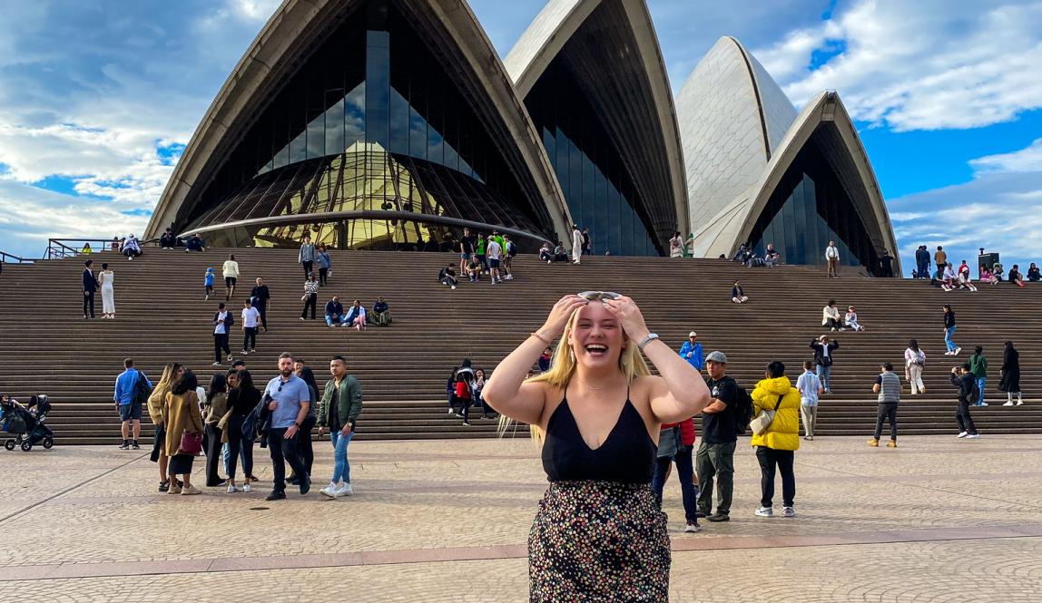 student standing in front of sydney opera house