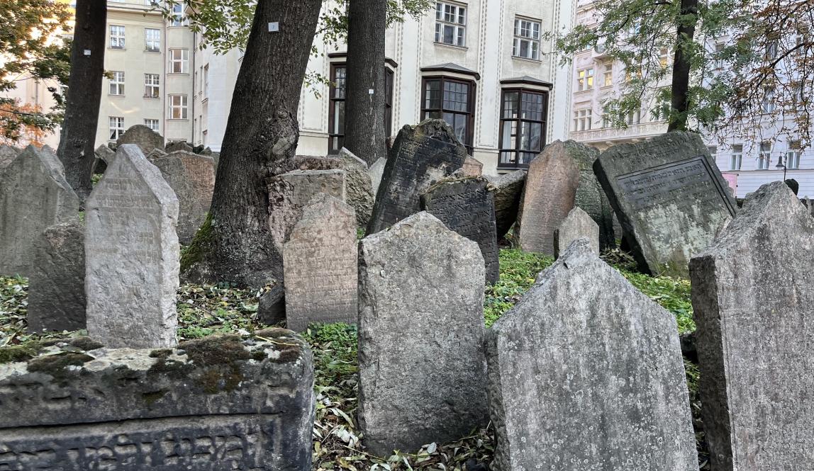 Photo of an old cemetery with many gravestones placed close together, leaning into each other. 