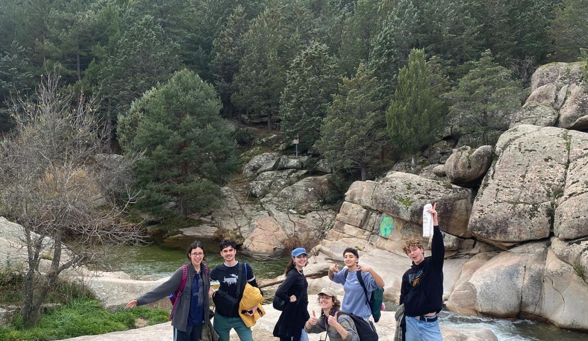 Group of friends standing together on a rock face, smiling