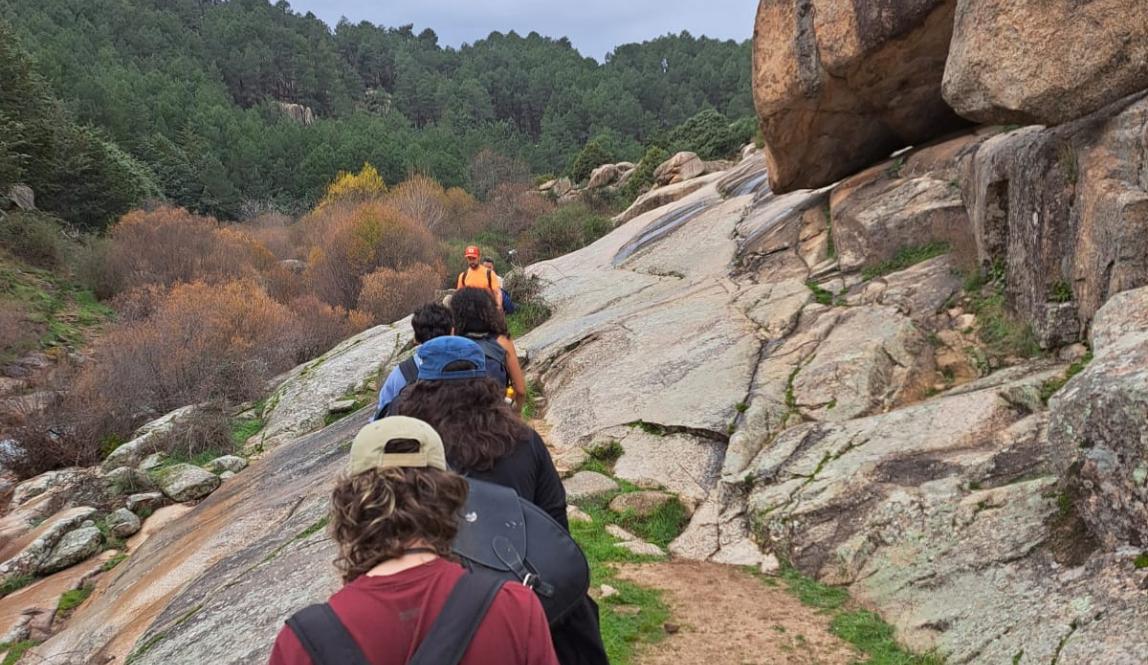 Group of friends hiking in a row along a rocky overlook