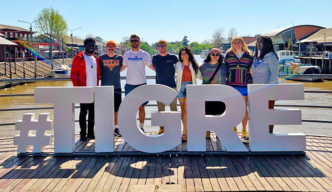 a group of students pose for a photo with a sign that says "#TIGRE"