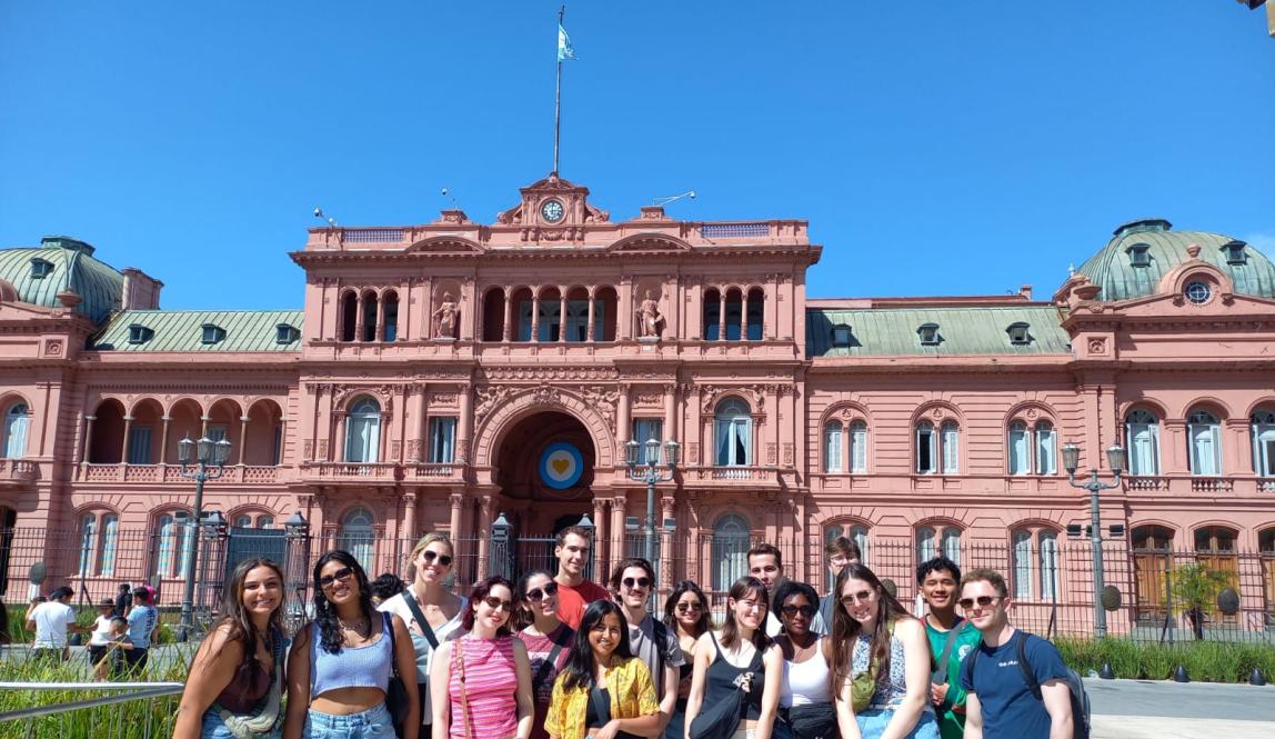 A group of students pose for a photo in front of La Casa Rosada, Argentina's capitol building