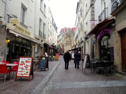 narrow cobblestone street lined with shops