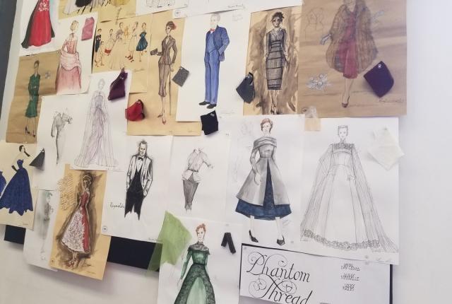 A board of outfit sketches and fabric swatches pinned up on a wall.