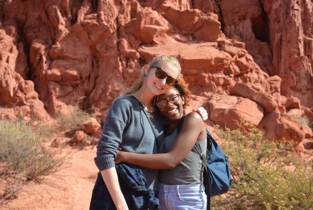 two students embrace for a photo