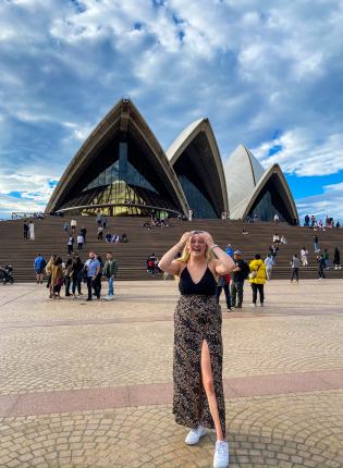 student standing in front of sydney opera house