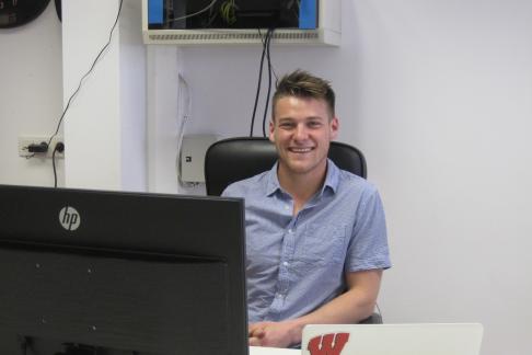 intern smiling at desk in front of computer