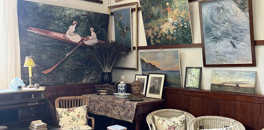 shows the inside of a room modeled to look like a painting workshop; there are some chairs, a mini table and various paintings by Claude Monet hung on the wall