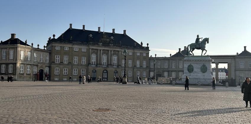 The Amalienborg Palace in Copenhagen, Denmark, with tourists walking around the area.