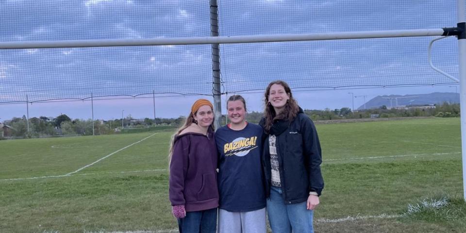 Two of my friends and I on a Gaelic football field 